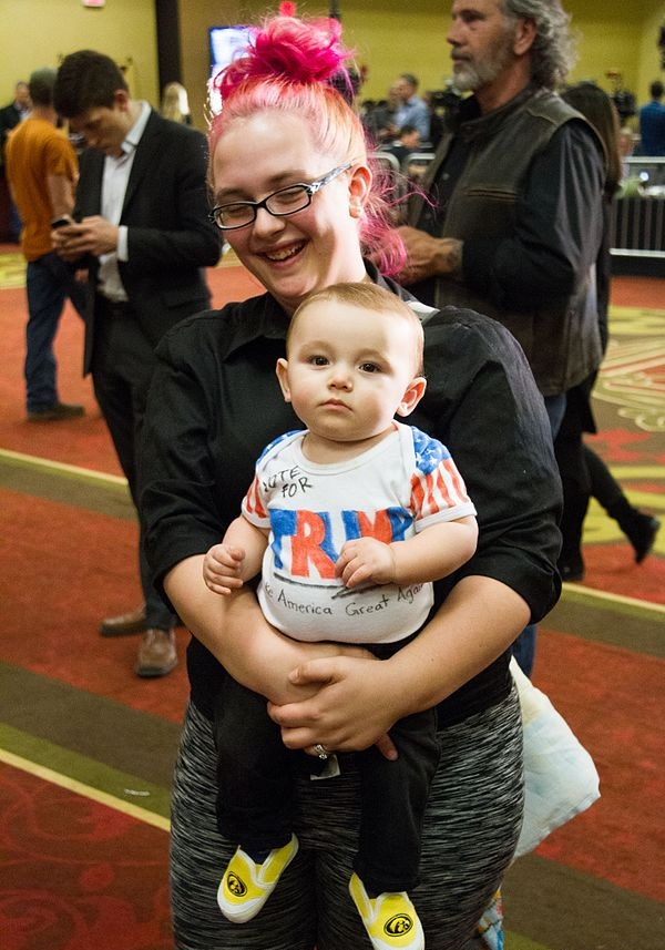 woman with pink hair holding baby