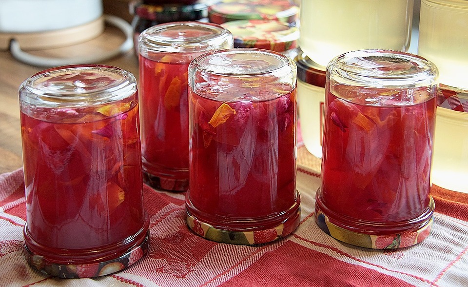 four jars of preserve canned with metal lids and updside down