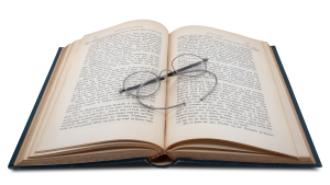 book open with glasses lying across the page