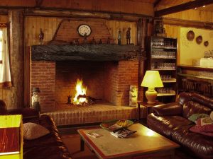 A cosy cabin lounge complete with fireplace and lamps