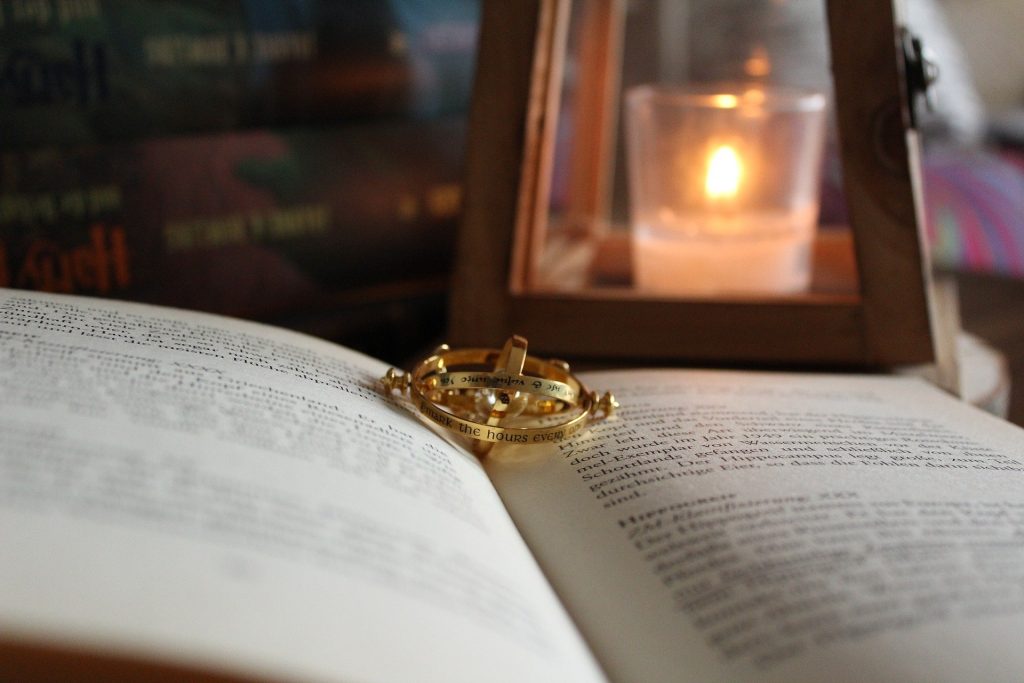 A small metal pendant is lying inside a book, it could be used to travel in time and get more stuff done