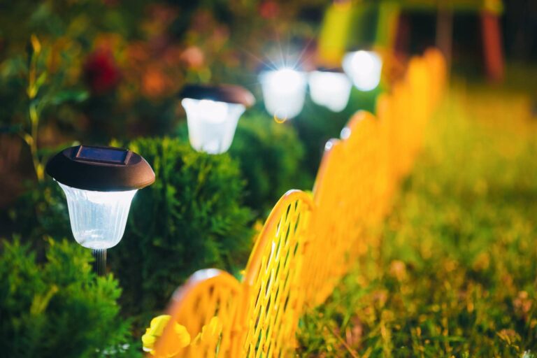 Decorative Small Solar Garden Light, Lanterns In Flower Bed In Green Foliage. Garden Design. Solar Powered Lamp